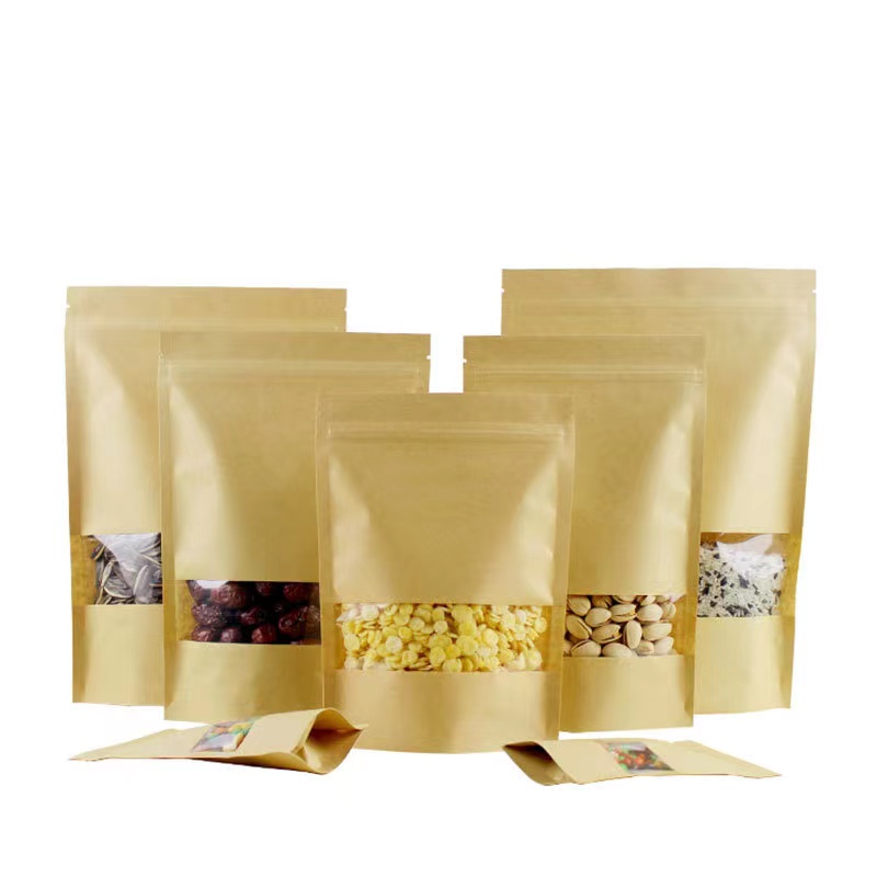 Multiple kraft stand-up pouches with clear windows displaying dried food items like nuts and fruits.