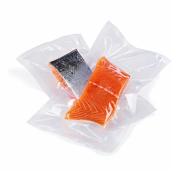 Two vacuum sealed raw salmon fillets in clear plastic packaging for food preservation.
