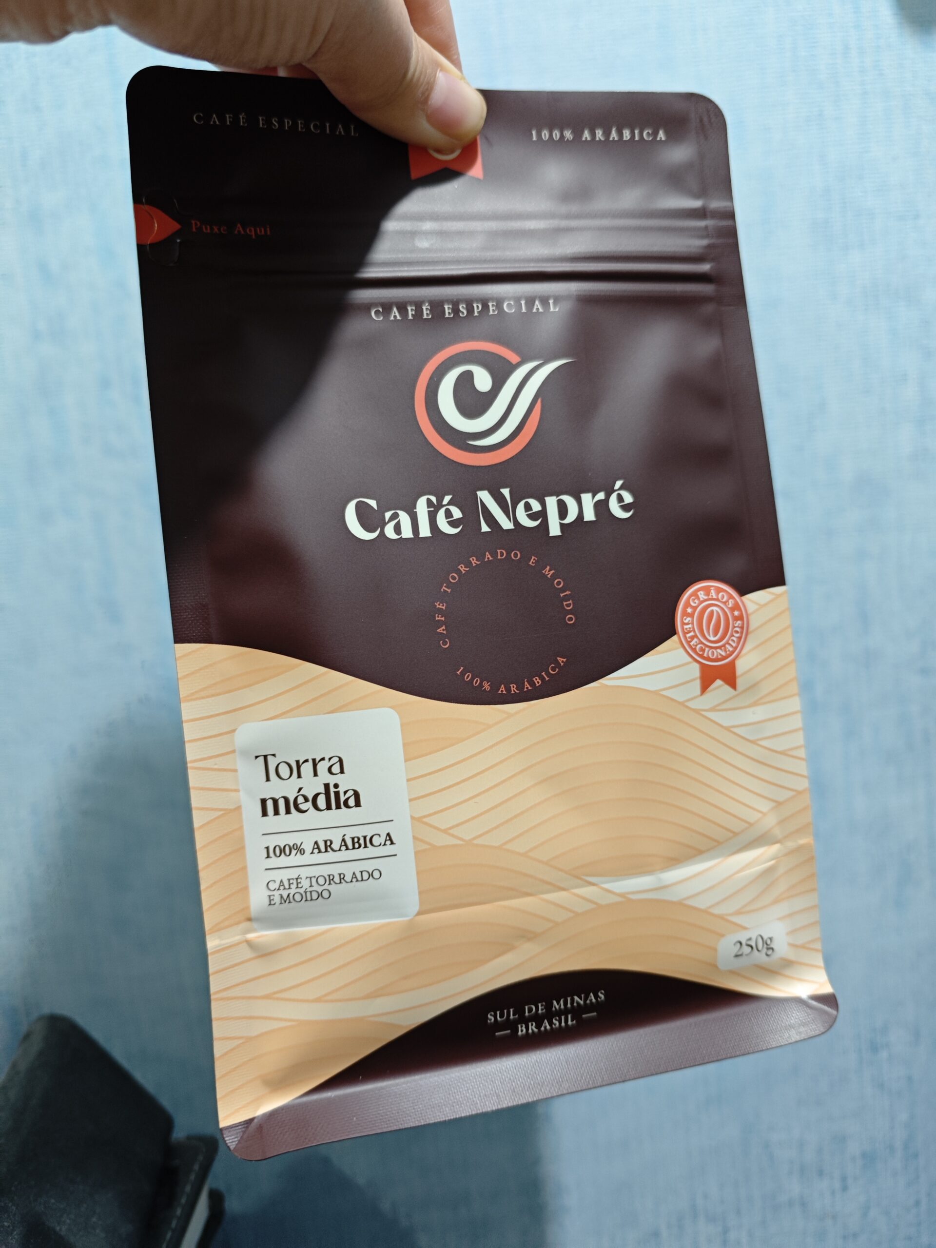 Café Nepré medium roast coffee pouch with resealable zipper, 100% Arabica, elegant brown and beige design.