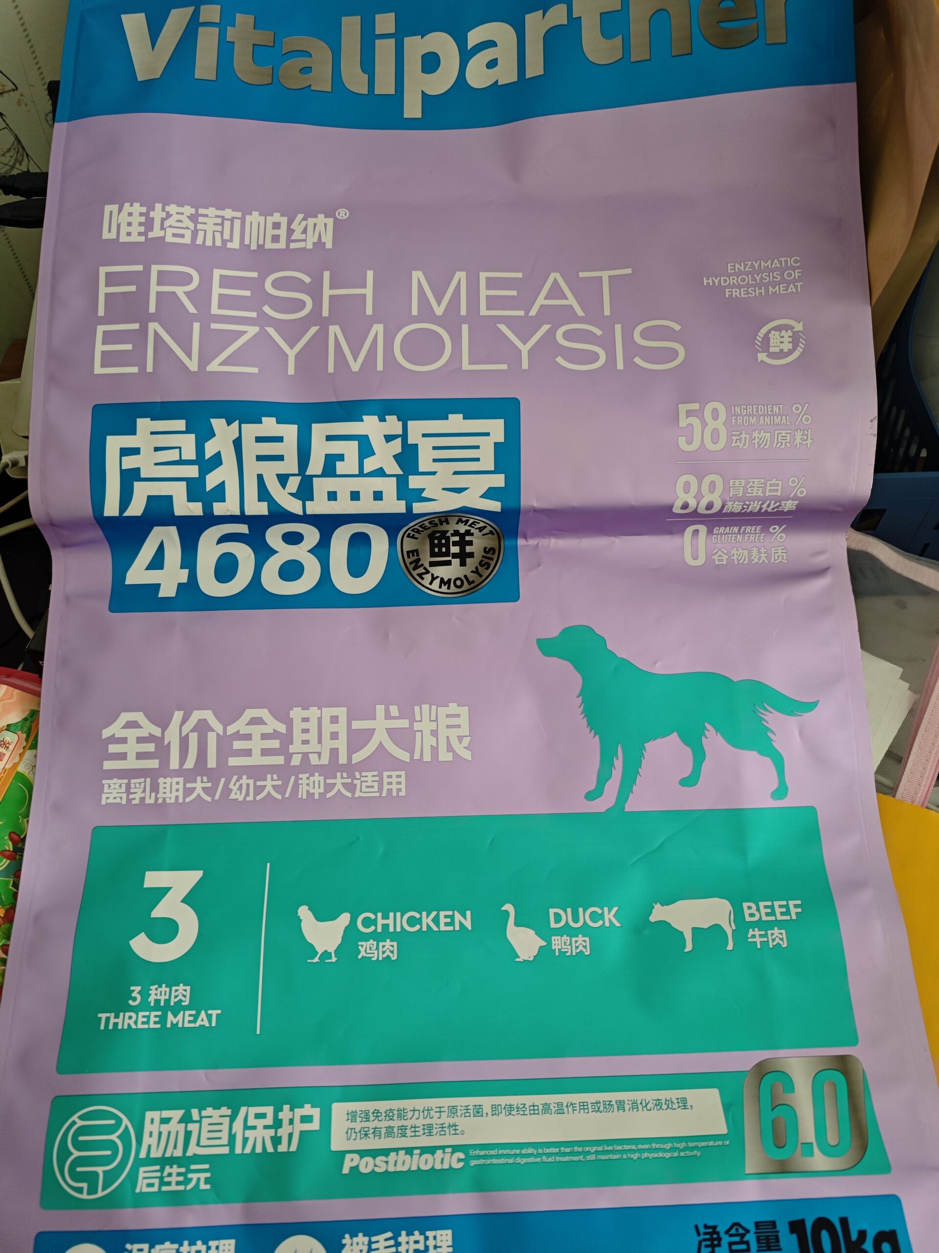 Colorful Vitalipartner dog food packaging with large silhouette of dog, labeled chicken, duck, and beef ingredients.