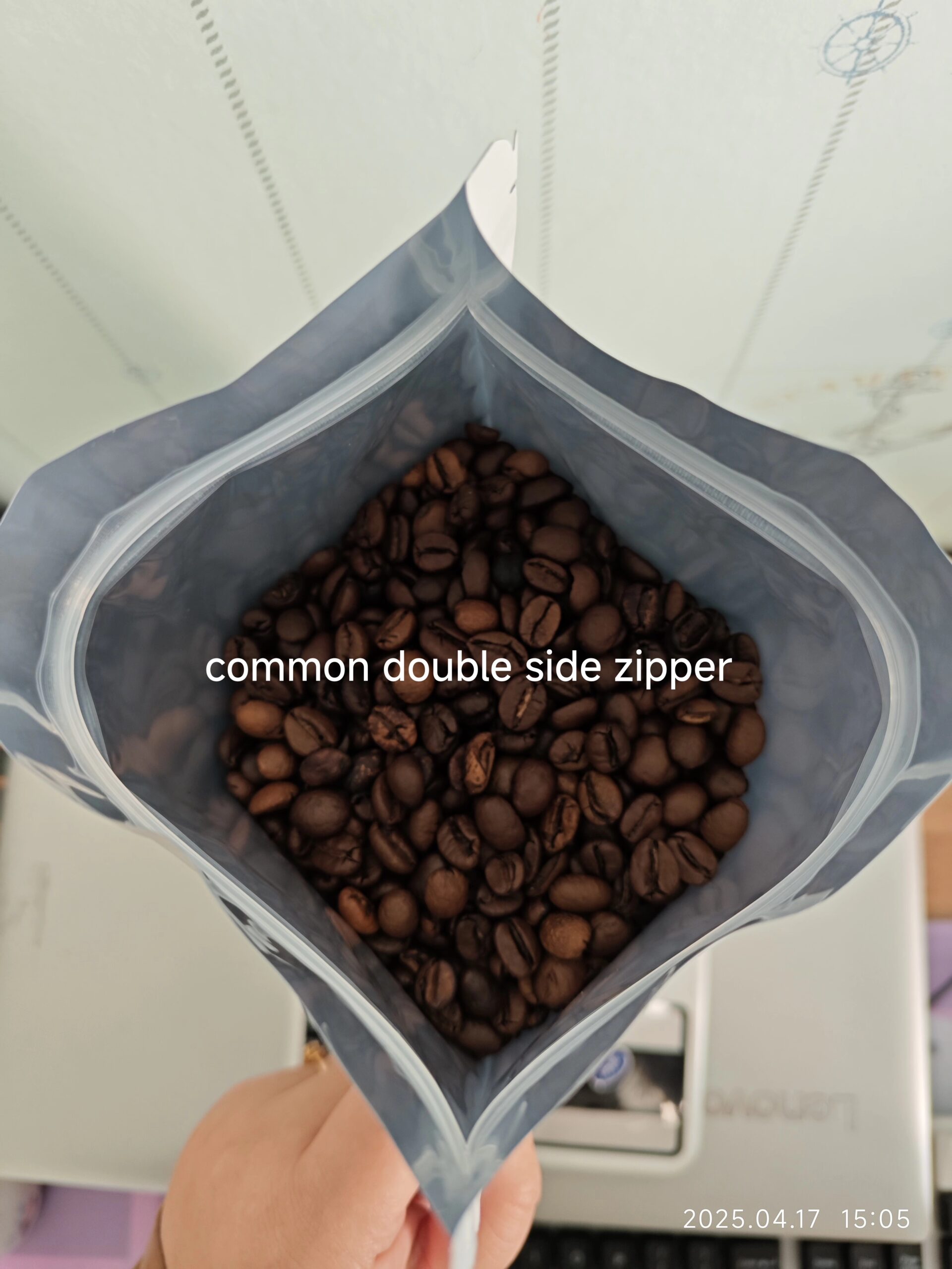 Open coffee pouch with common double side zipper, filled with roasted coffee beans.
