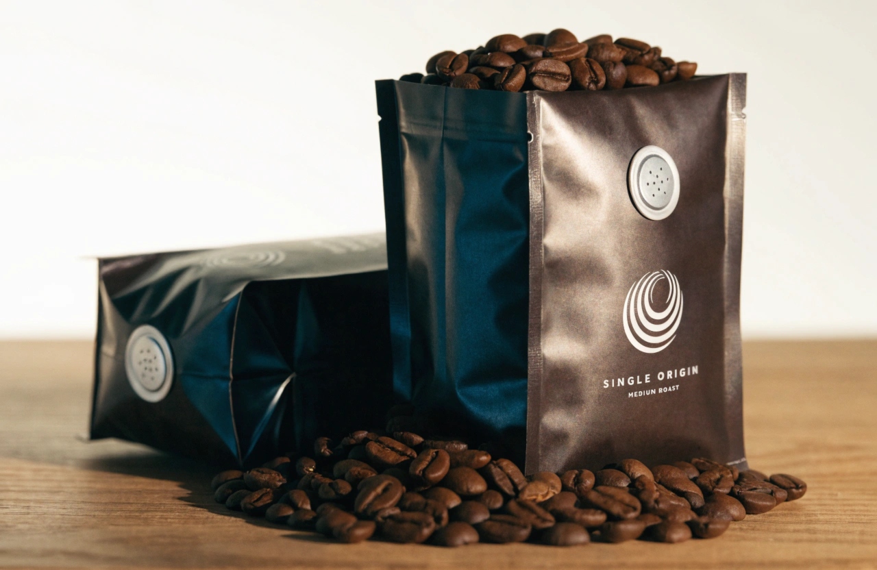 Black coffee valve bags preserving roasted coffee bean freshness and aroma.